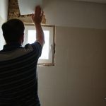 Carreleur posant du carrelage mural dans une salle de bain en renovation